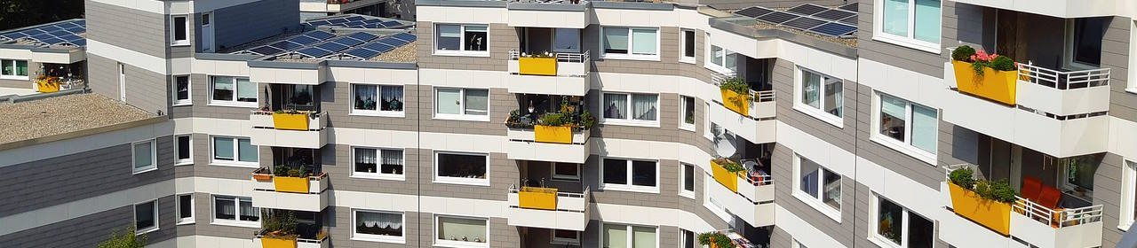 Ansicht eines Mehrfamilienhauses mit Solarpaneelen auf dem Dach (Titelbild) Ansicht eines Mehrfamilienhauses mit Solarpaneelen auf dem Dach (Titelbild)