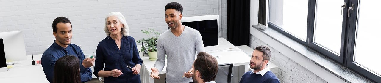 Ansicht von oben auf mehrere Menschen in einem intensiven Gespräch in einem Schulungsraum (Titelbild) Ansicht von oben auf mehrere Menschen in einem intensiven Gespräch in einem Schulungsraum (Titelbild)