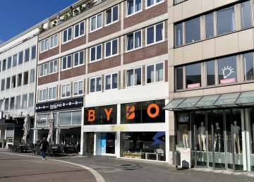 Eine Häuserfassade an einer Straße in Bochum, im Erdgeschoss ist ein Schaufenster gro mit den Bichstaben ByBo gekennzeichnet.